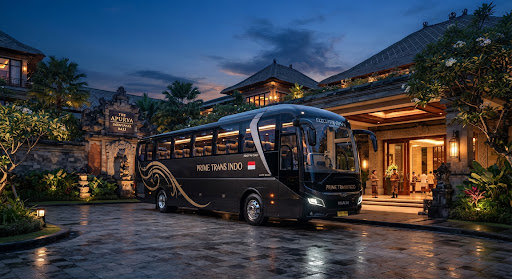 Bus pariwisata eksekutif terparkir di depan resort mewah pada sore hari