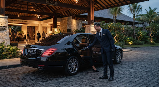 Chauffeur berseragam membuka pintu mobil di lobi hotel bintang lima